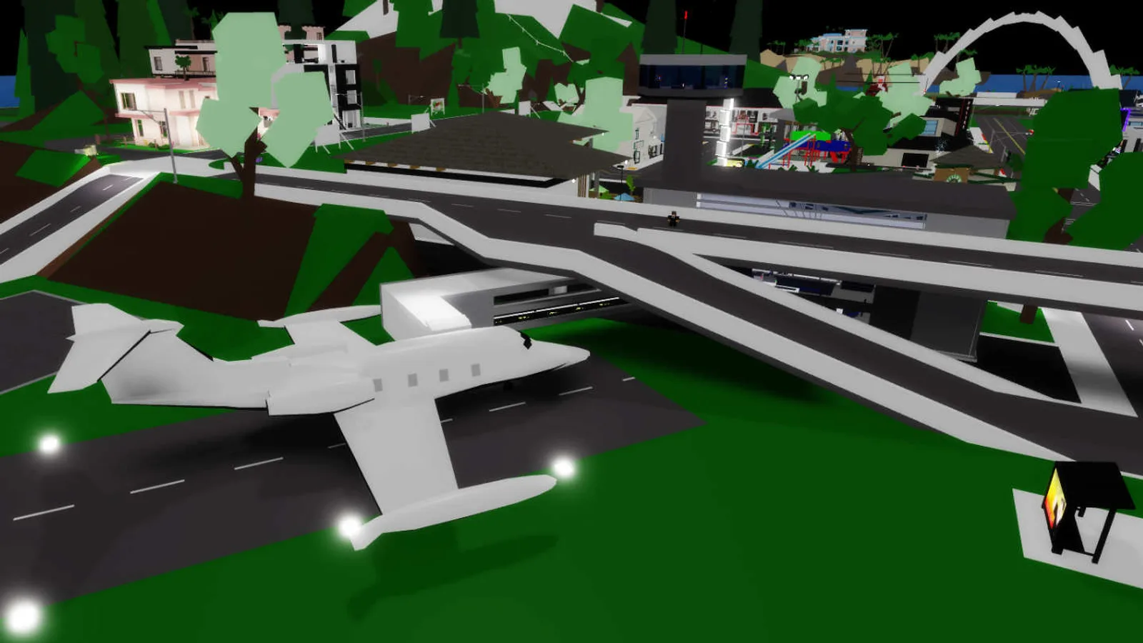 In-game render of Brookhaven RP's airport area at night, with a small plane parked on the runway beneath an overpass