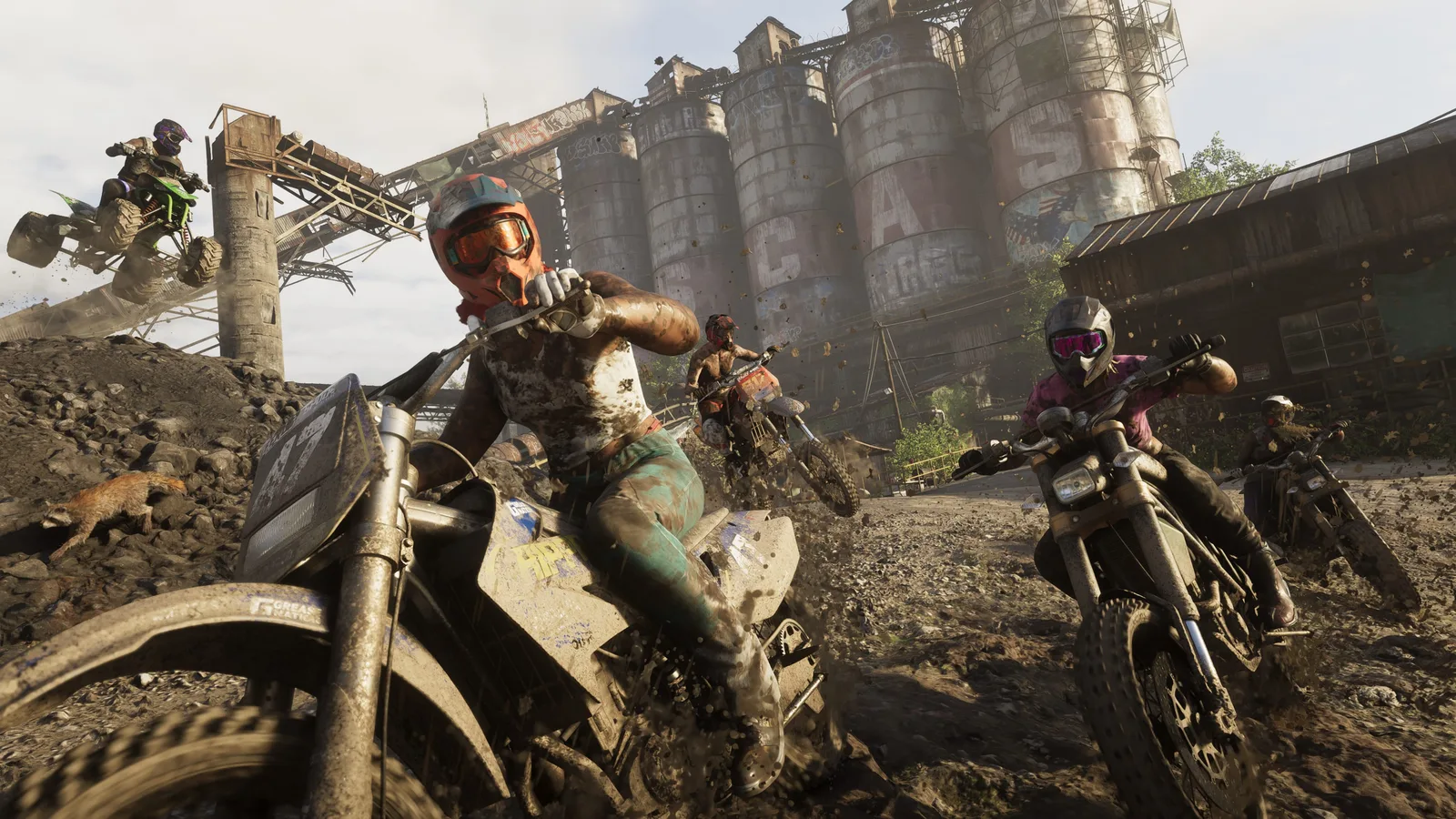 Official screenshot of off-road motorbike racers riding past rusted industrial silos at an abandoned mine in Mount Kalaga National Park in Grand Theft Auto VI